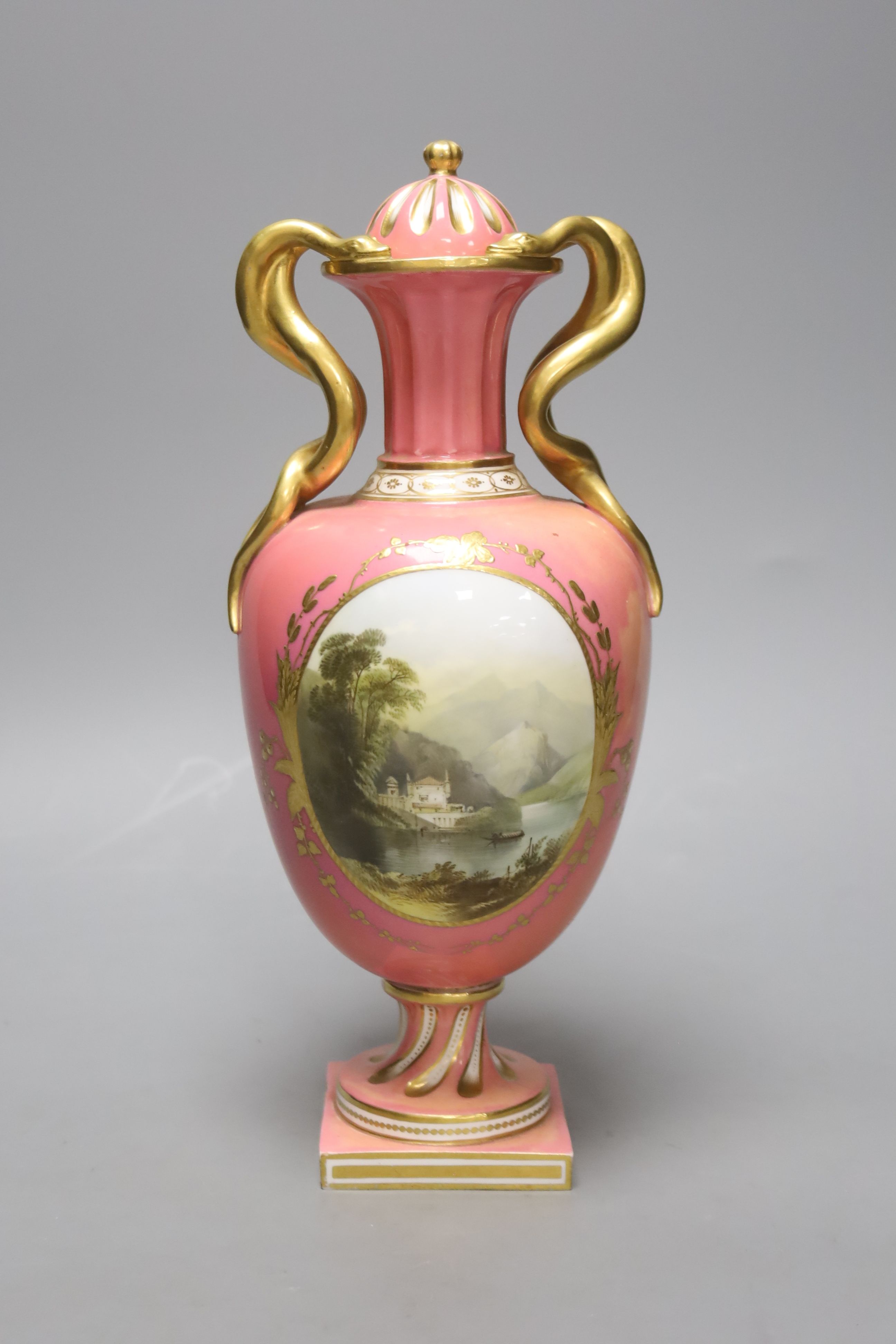 A Coalport pink ground vase and cover, with serpent handle painted with a landscape c.1825, height 29cm